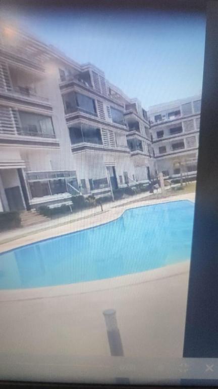 vista para uma piscina em frente a um edifício em appartement luxe em Mohammedia