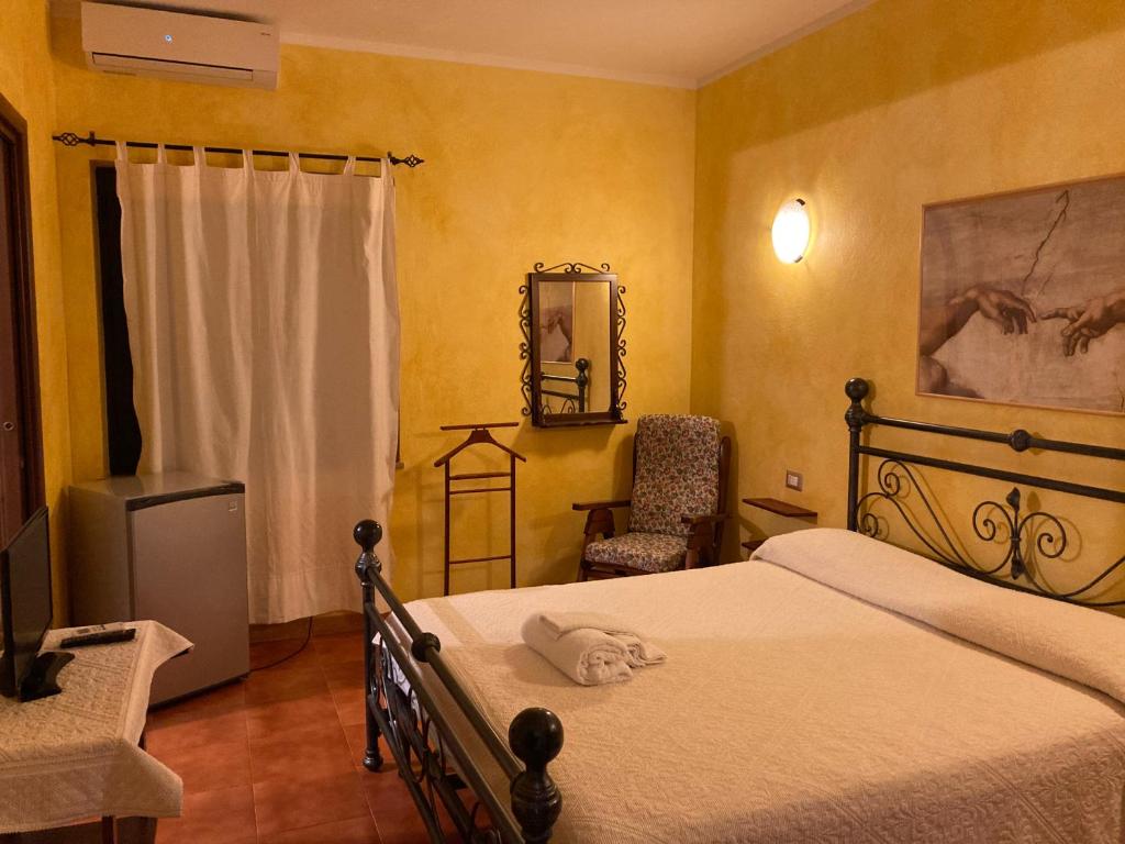 a bedroom with a bed and a chair and a mirror at Araxi in Villa San Pietro
