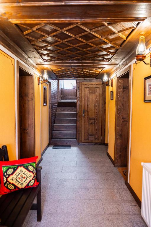 a hallway with stairs and a room with yellow walls at Къща ЕТНО in Koprivshtitsa