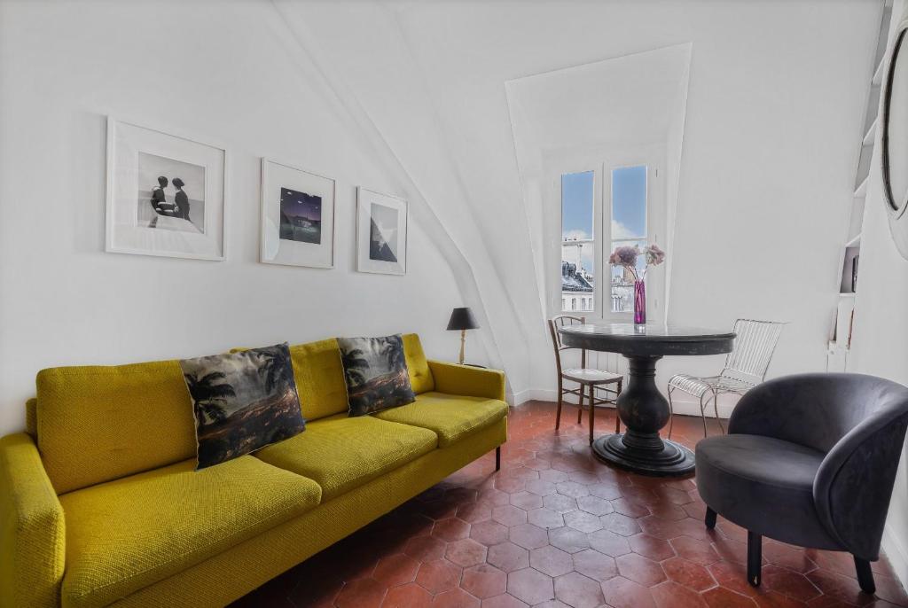 sala de estar con sofá amarillo y mesa en Benjamine en París