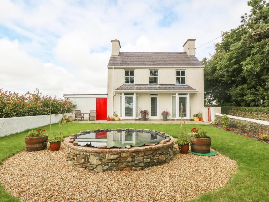 a house with a fire pit in the yard at Bryn Tirion in Holyhead