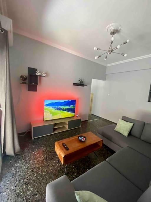 a living room with a couch and a tv at Lovely flat Korydallos in Piraeus
