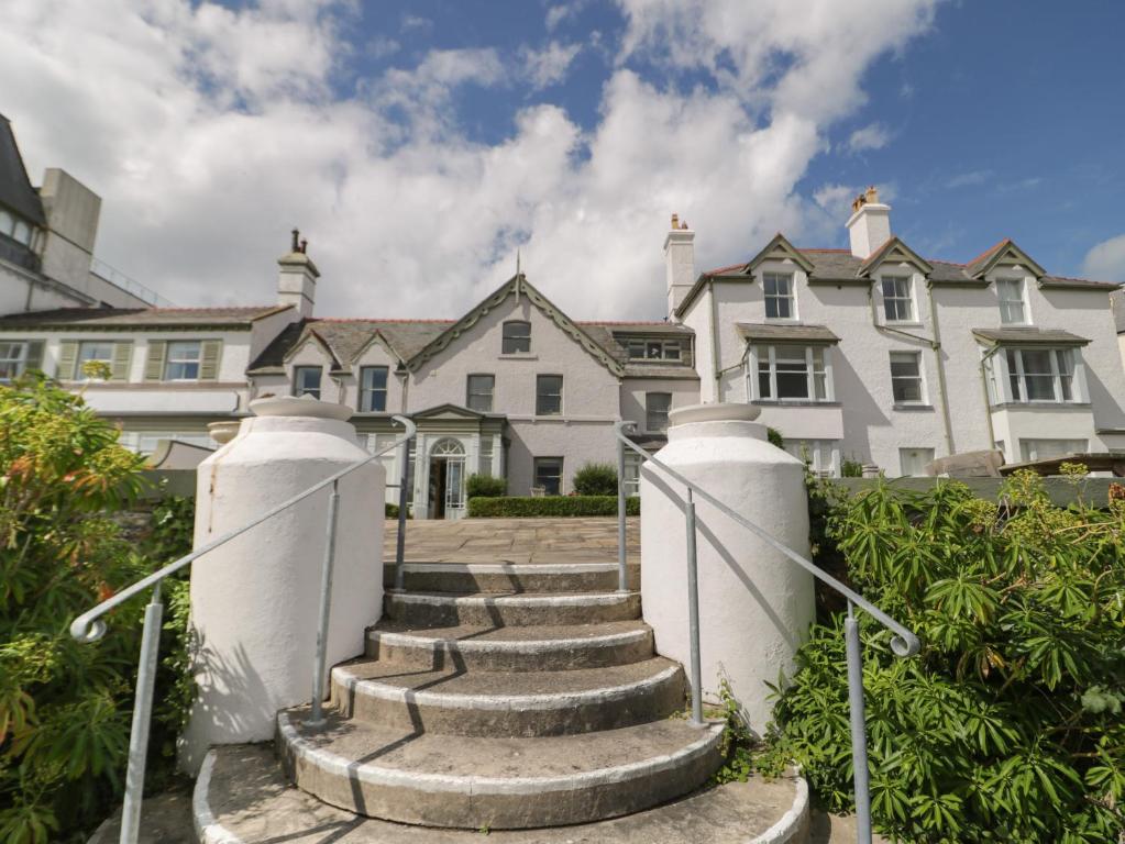 a large white house with stairs in front of it at The Moorings in Deganwy