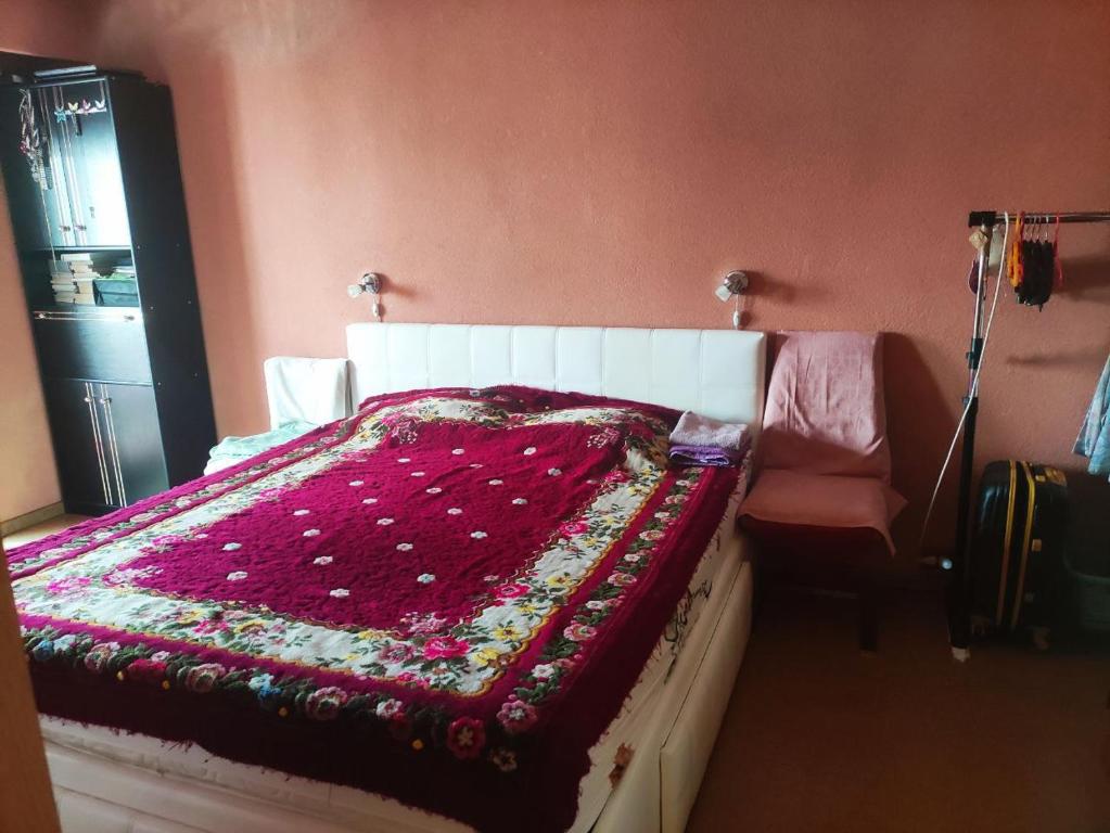 a bedroom with a bed with a red blanket and a chair at Dorobantilor House in Cluj-Napoca