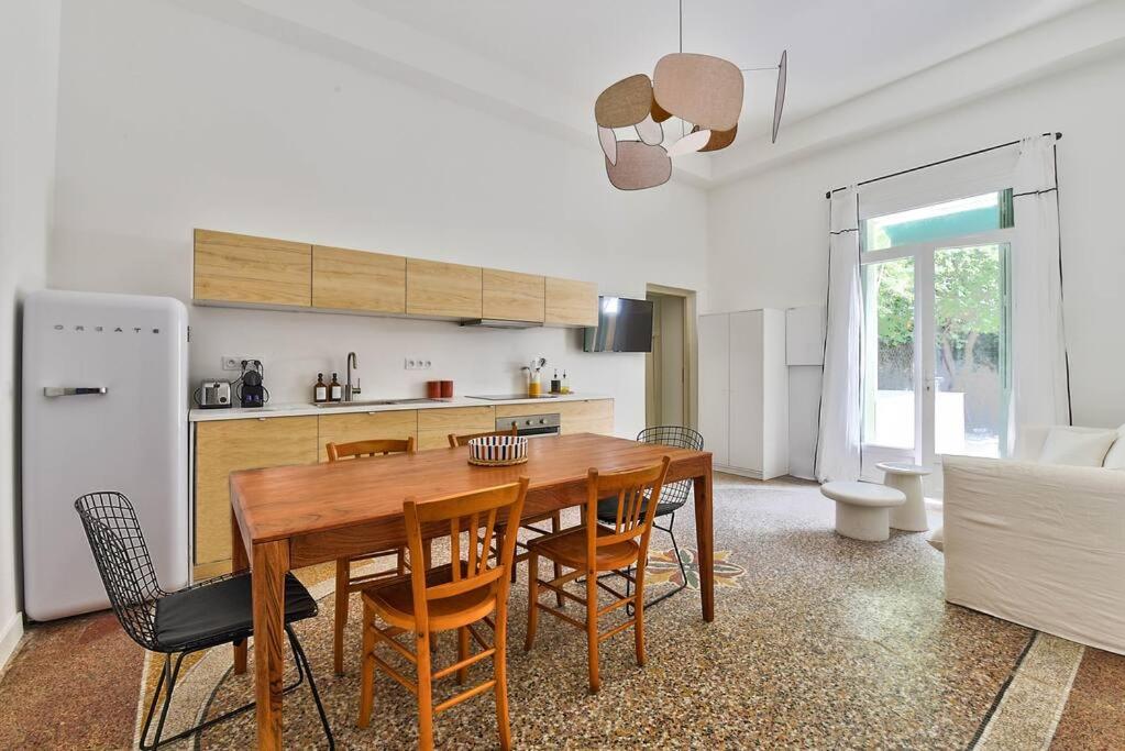 una cucina e una sala da pranzo con tavolo e sedie in legno di NOCNOC - Le Terrazzo - Petite piscine et jardin en ville a Montpellier