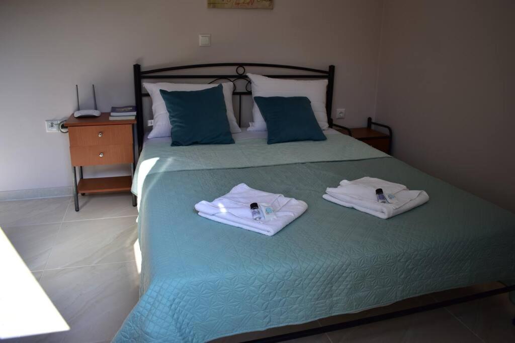- une chambre avec un lit vert et des serviettes dans l'établissement Magenta, à Igoumenítsa