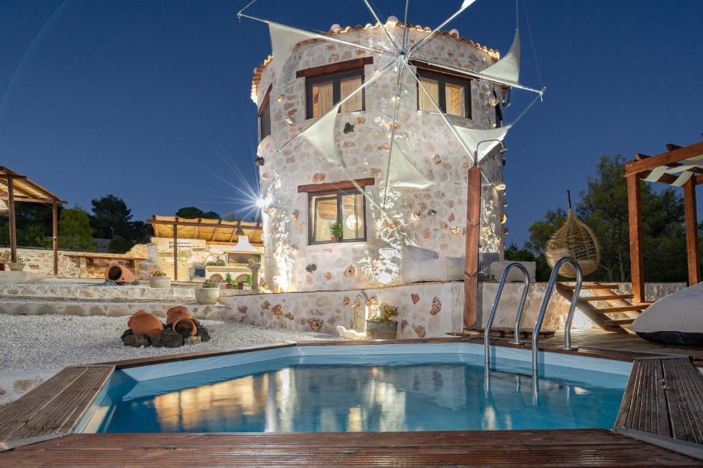 a villa with a swimming pool in front of a building at Zante Hidden Hills in Koiliomenos