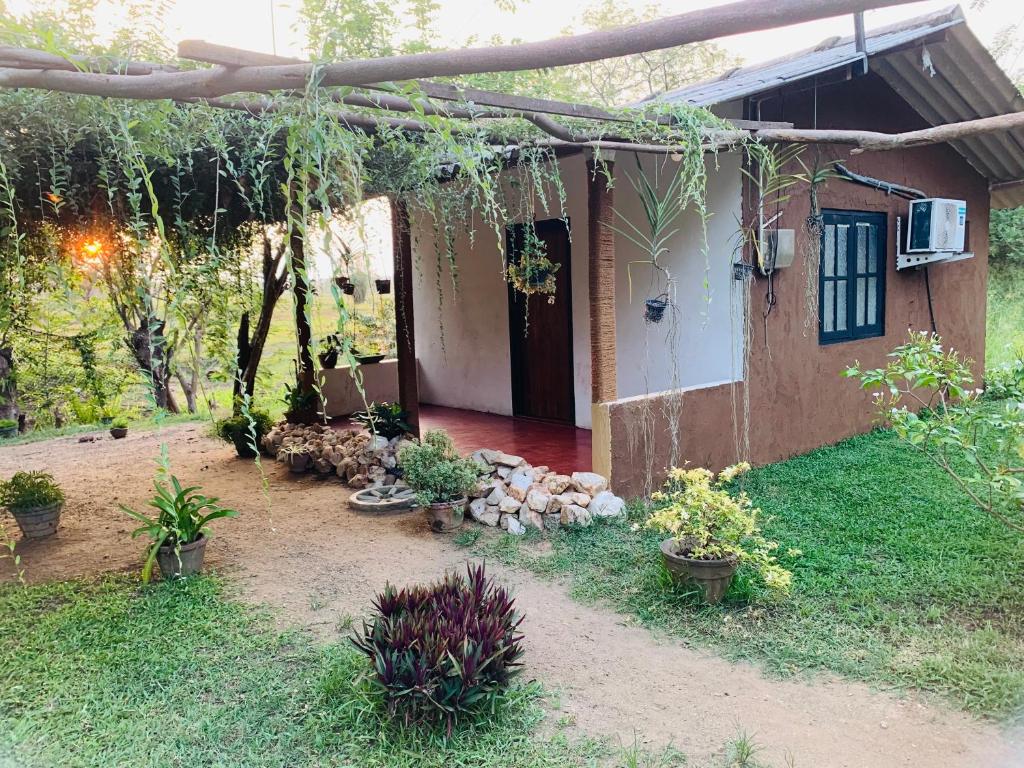 una casa con un patio con plantas delante en Thanamal-villa, en Tanamalwila