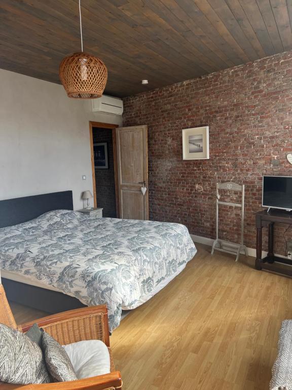 ein Schlafzimmer mit einem Bett und einer Ziegelwand in der Unterkunft Dolce far niente in Brügge