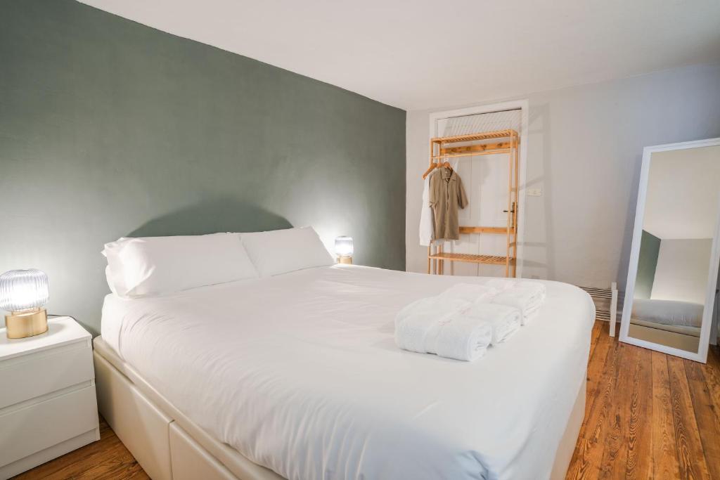 una camera da letto con un grande letto bianco con lenzuola bianche di Double Room, attached bathroom - Casa del Indiano a La Orotava