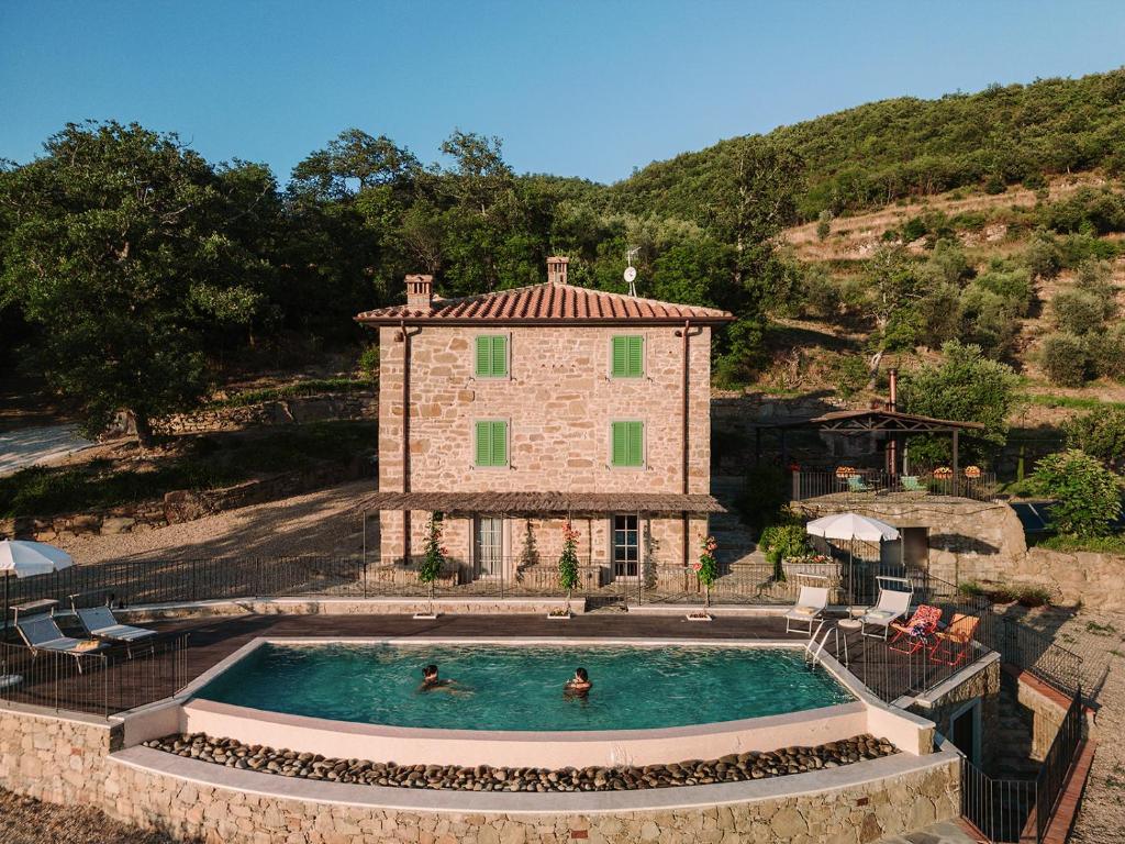 una casa con piscina frente a ella en Agriturismo Casa Augusta, en Castiglion Fibocchi