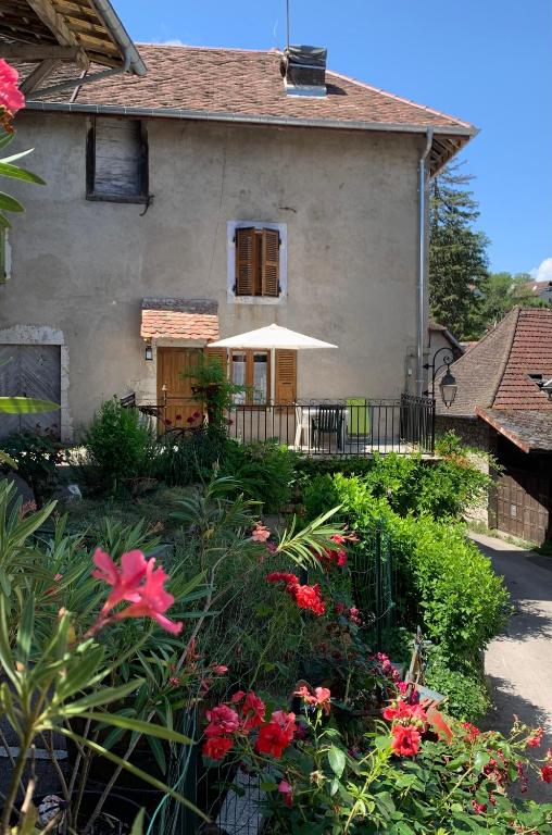 une maison avec un jardin fleuri devant elle dans l'établissement Gîte Chez Charlot, à Chanaz