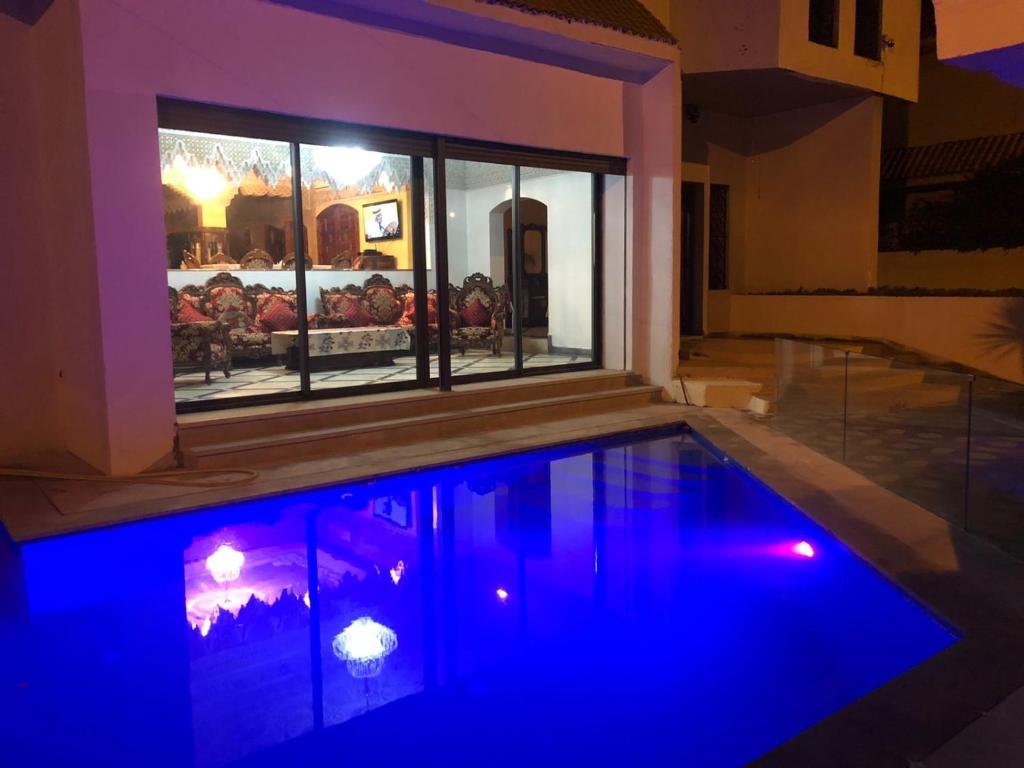 Villa Hanaa في المحمدية: حمام سباحة مع أضواء زرقاء في المنزل