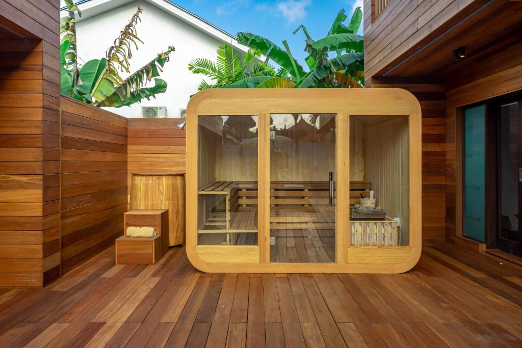 a wooden building with a glass door on a deck at ZenDen in Canggu