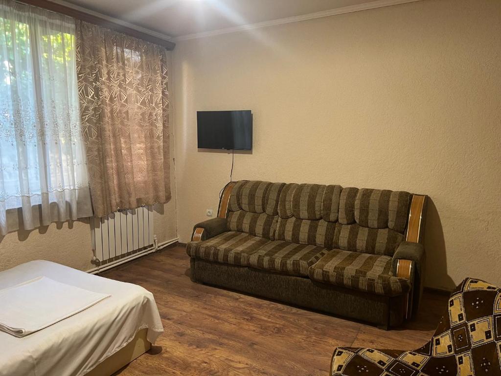 uma sala de estar com um sofá e uma televisão em Touristic House KAEL em Musalerr