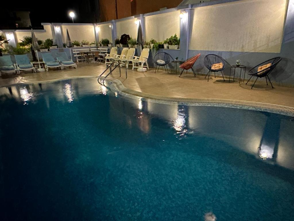 Una gran piscina con sillas y una mesa. en Hedi Sozopol, en Sozopol