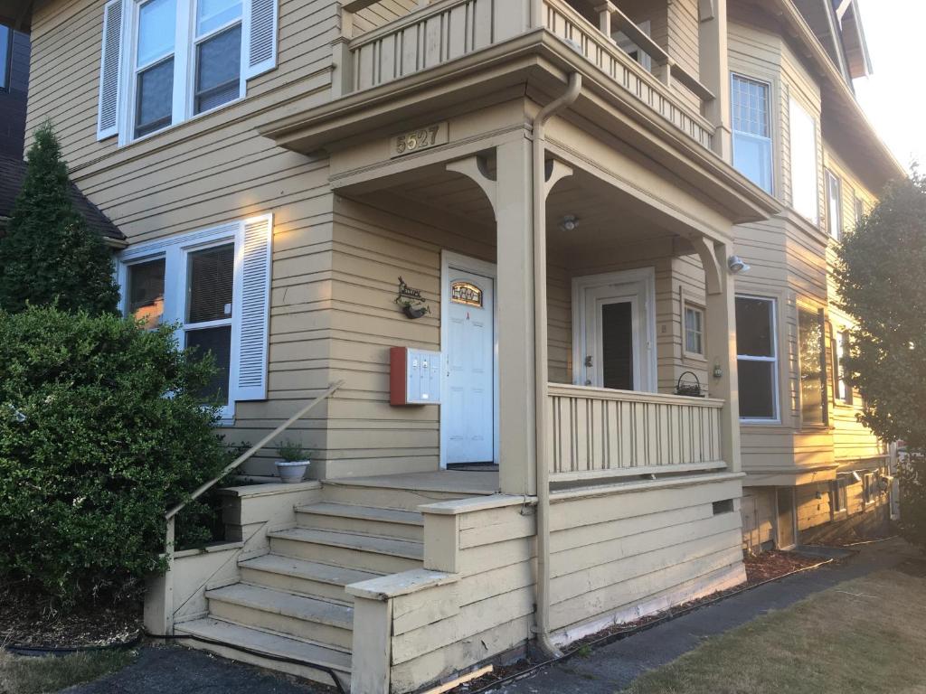 une maison avec une terrasse couverte et des escaliers en face de celle-ci dans l'établissement Entire cozy home in U-District, à Seattle