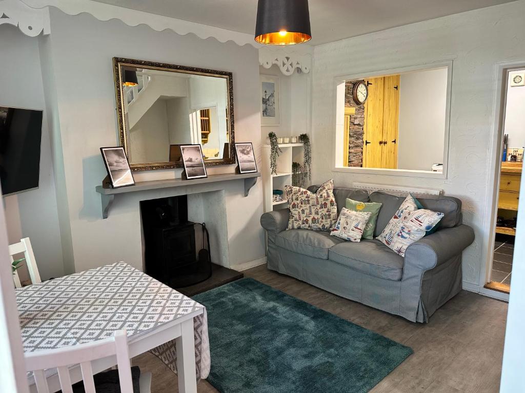 uma sala de estar com um sofá e um espelho em Brixham Cottage with views em Brixham