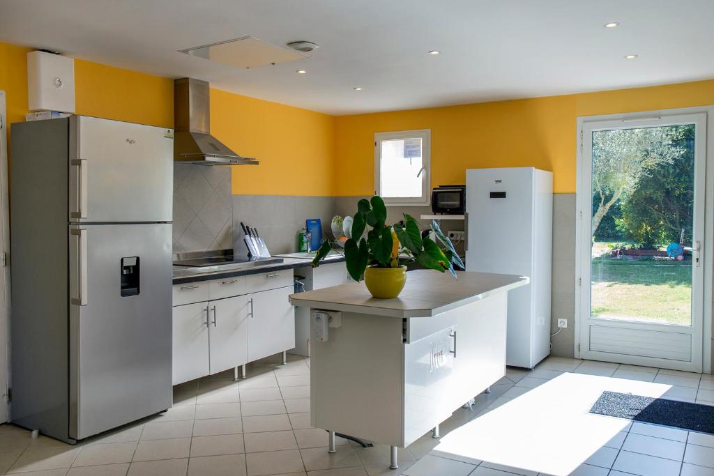 a kitchen with white appliances and yellow walls at Locatlantique in Aytré