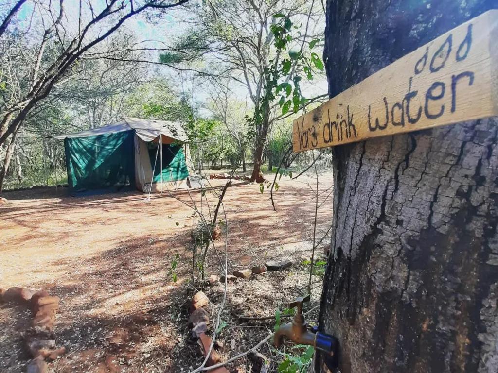 a sign on a tree in front of a tent at Impala trailor tent in Thabazimbi