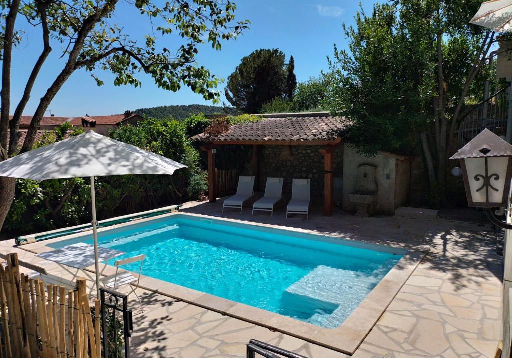 een zwembad met een parasol en een prieel bij Maison Seillans les Fontaines in Seillans
