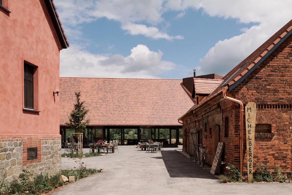 a courtyard in a brick building with tables and chairs at Michelberger Farm in Vetschau