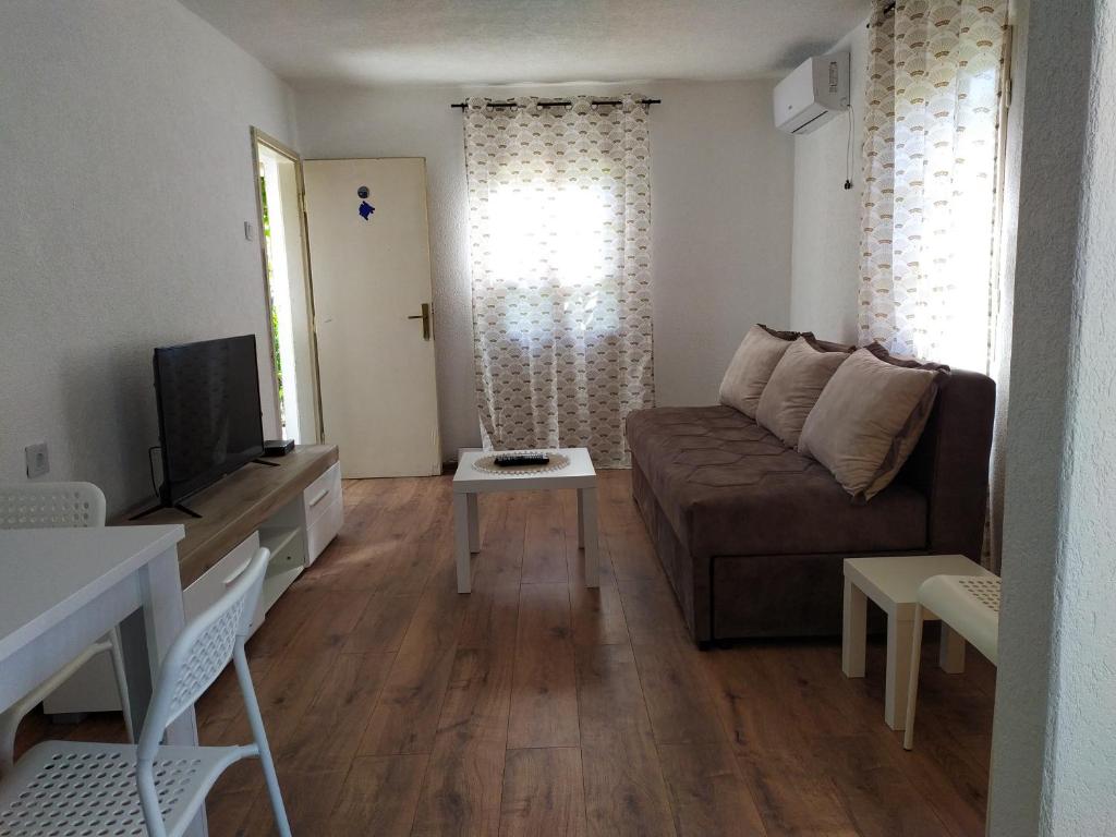 een woonkamer met een bank en een tv bij Olive House in Petrovac na Moru