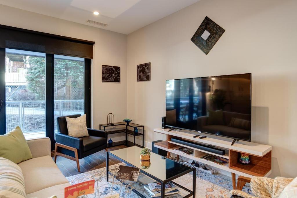 a living room with a large flat screen tv at Downtown Condo City Center in Asheville