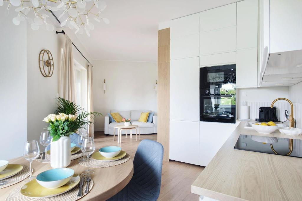 a kitchen and living room with a dining table and a kitchen at LUNA Apartment in Toruń