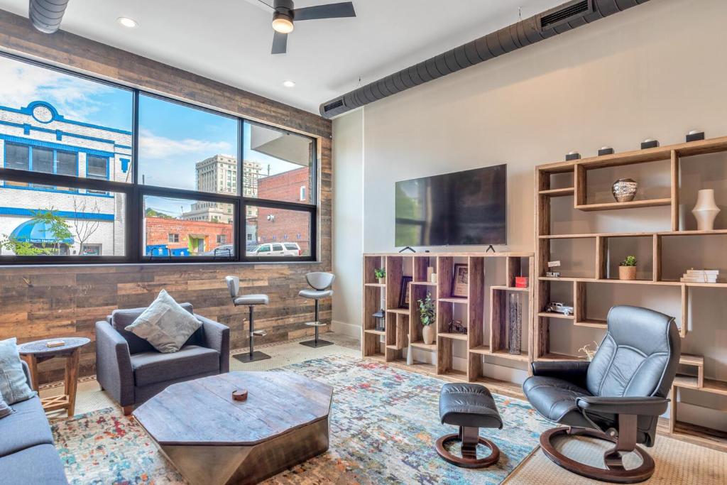 a living room with furniture and a large window at Exceptional Downtown Condo in Asheville