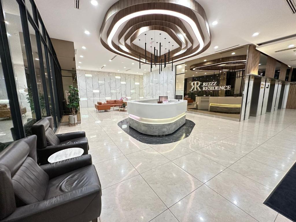 eine Lobby mit einer Badewanne in der Mitte eines Gebäudes in der Unterkunft Reizz Residence by Perkasa in Kuala Lumpur