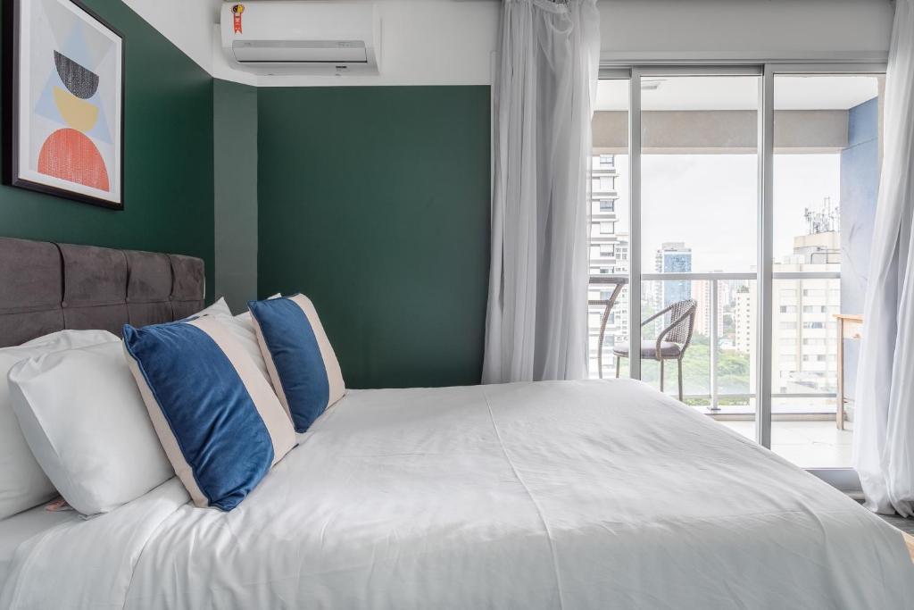 um quarto com uma cama grande e almofadas azuis e brancas em Tabas - VN Quatá em São Paulo