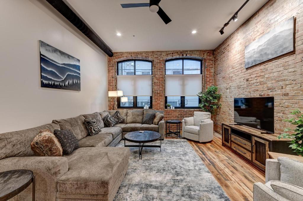 a living room with a couch and a tv at Fabulous Downtown 2 bedroom Condo in Asheville