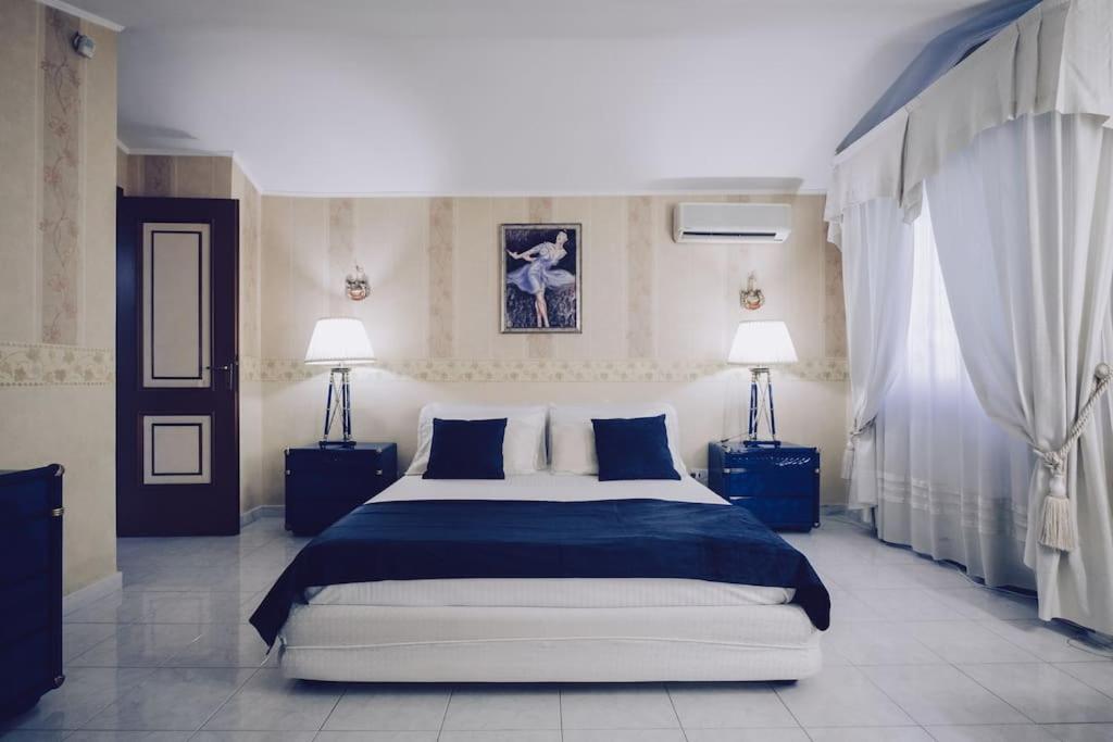een slaapkamer met een groot bed en 2 lampen bij La Maison de Monique - Luxury Villa - 8 Beds, Outdoor Fireplace, Golf! in Marco Simone