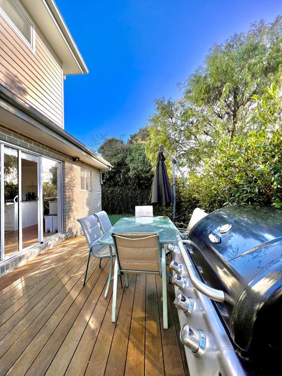 a deck with a table and chairs and a boat at Rosebud Lovely House 2 - Mornington Peninsula 4 BR 3 Bath 2 story holiday house - BBQ - Beach - Hot spring in Rosebud