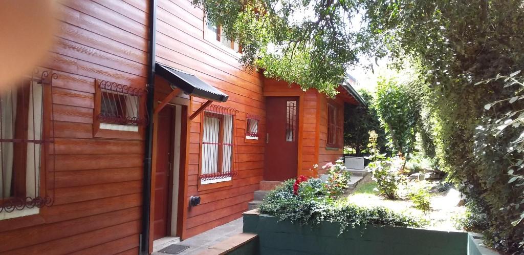 an orange house with a door and a yard at El Maiten Bariloche in San Carlos de Bariloche