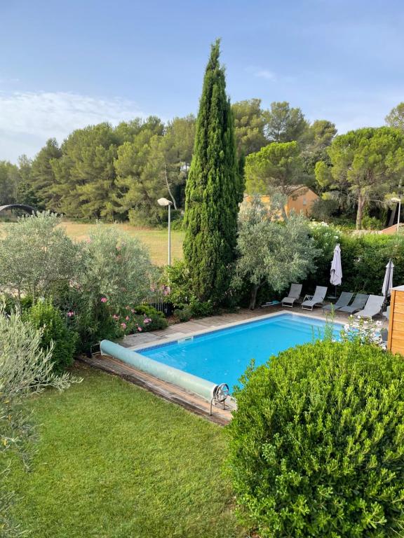 une piscine dans un jardin avec des buissons et des arbres dans l'établissement Grande maison à teyran (34), à Teyran