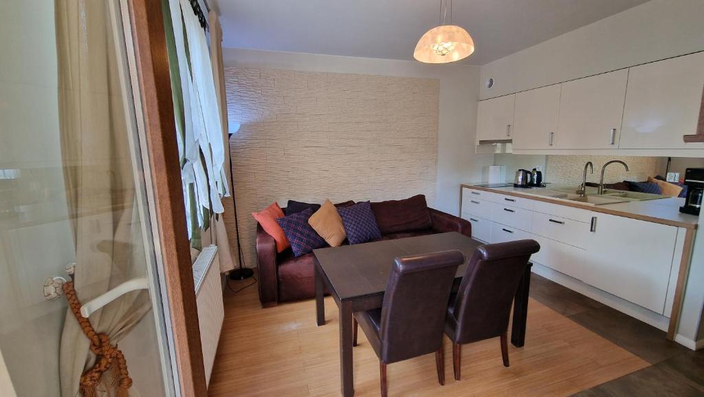 eine Küche mit einem Tisch und einem Sofa in einem Zimmer in der Unterkunft Lux Apartment Art in Polanica-Zdrój