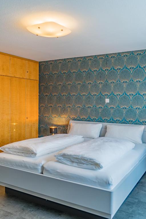a bedroom with a large bed with a wall at Ferienwohnung Nadine Petschler in Obereisenheim