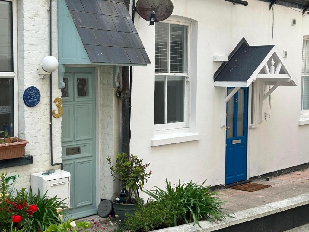 a house with a blue door and a window at Beachside Mews in Broadstairs