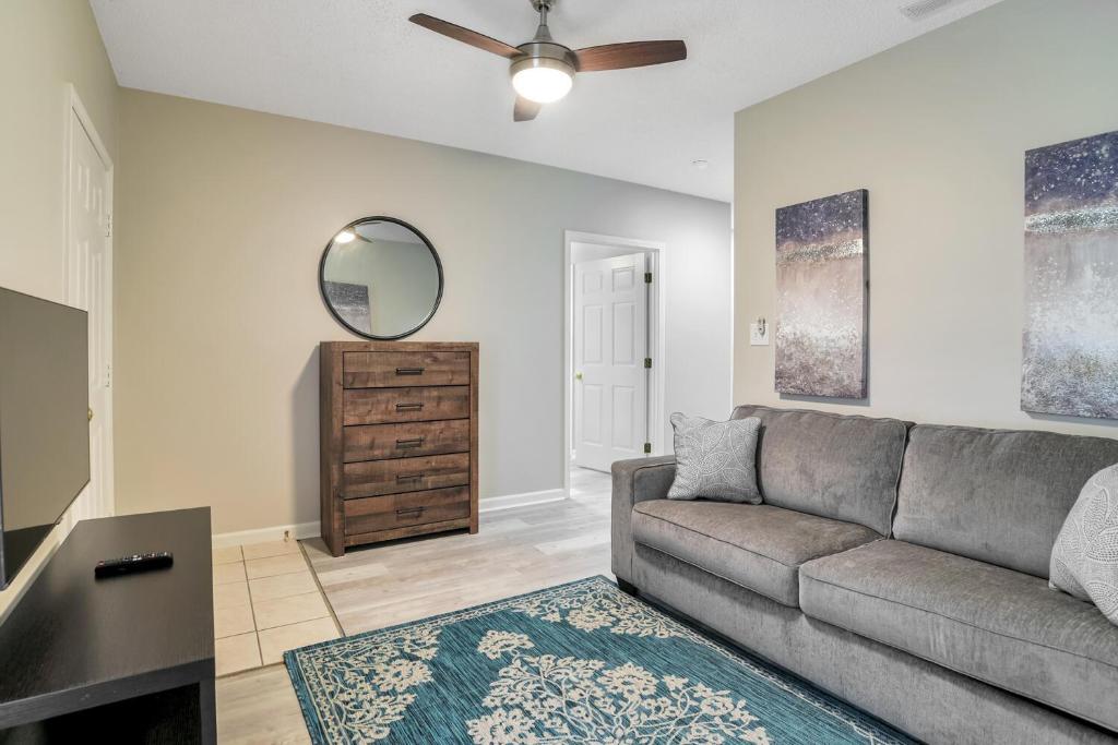 a living room with a couch and a mirror at South Asheville Townhome 12 A in Arden
