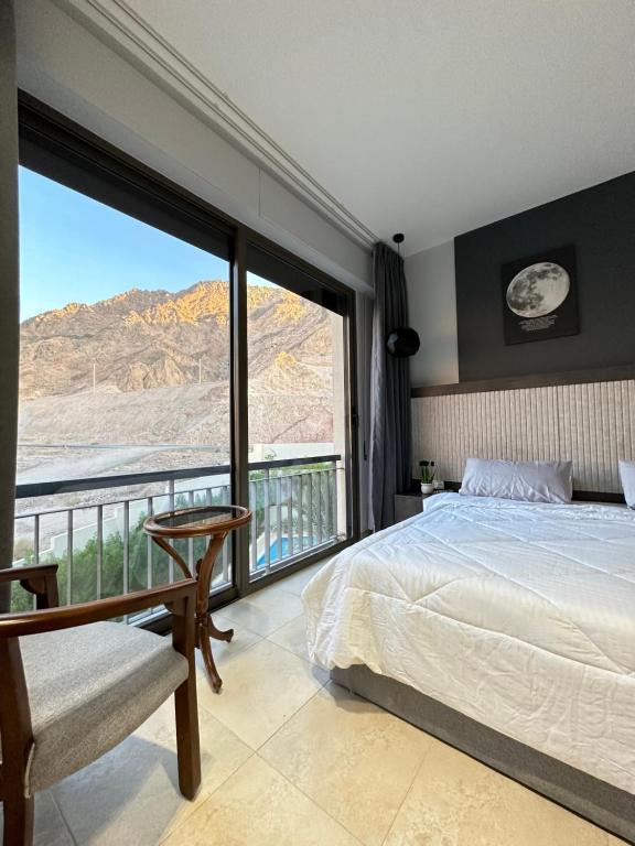 een slaapkamer met een bed en een groot raam bij aladnan Chalet alraha village in Aqaba