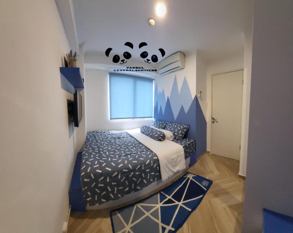 a bedroom with a bed with a panda bear on the wall at Apartment Kalibata City by PanBul in Jakarta