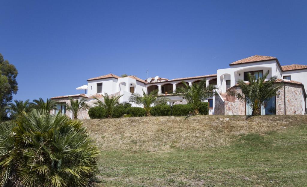 una gran casa blanca en una colina con palmeras en Las Palmas, en Alghero