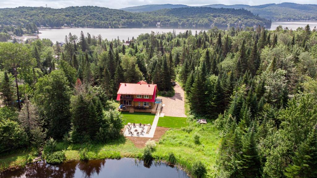 una vista aérea de una casa en una isla en un lago en Les Chalets Tourisma - Chalet en bois rond avec spa et lac privé - Le Caribou en Sainte-Catherine