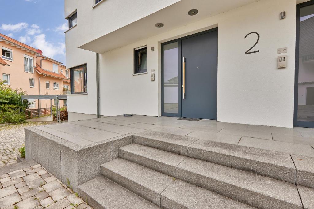 a white house with a blue door and stairs at Villa-Eggert in Bretten