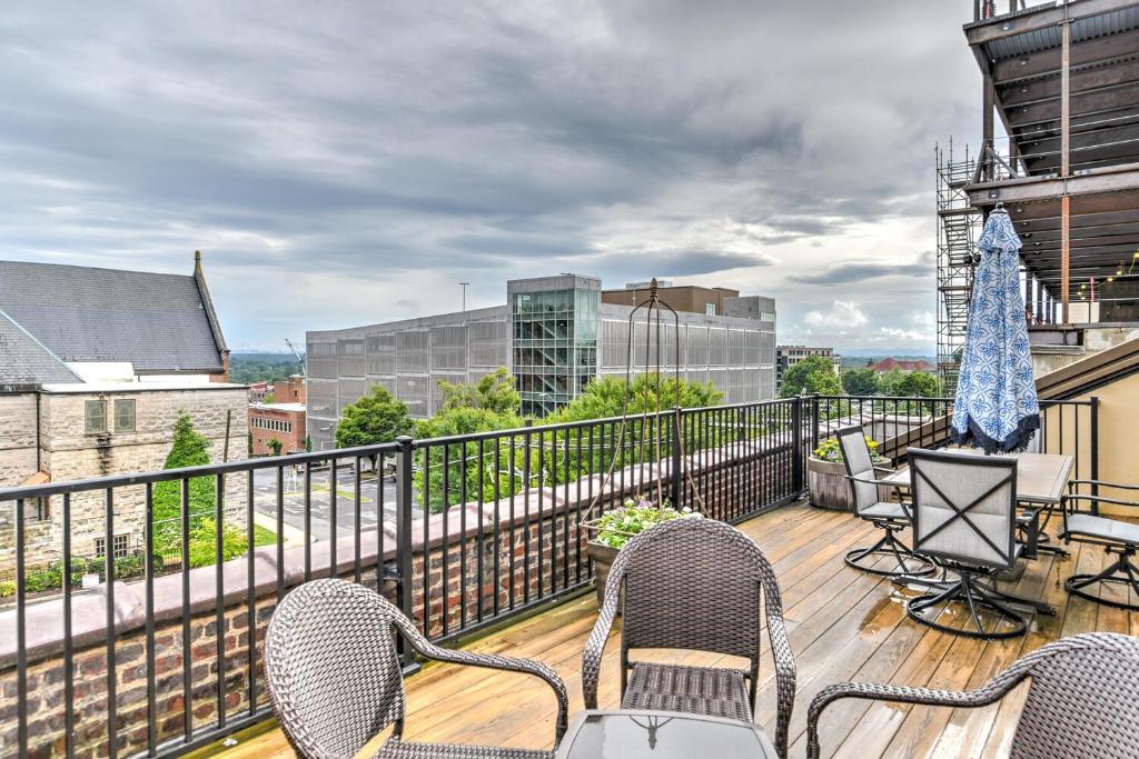 a balcony with chairs and an umbrella on a building at Magnificent S and W Building Condo in Asheville