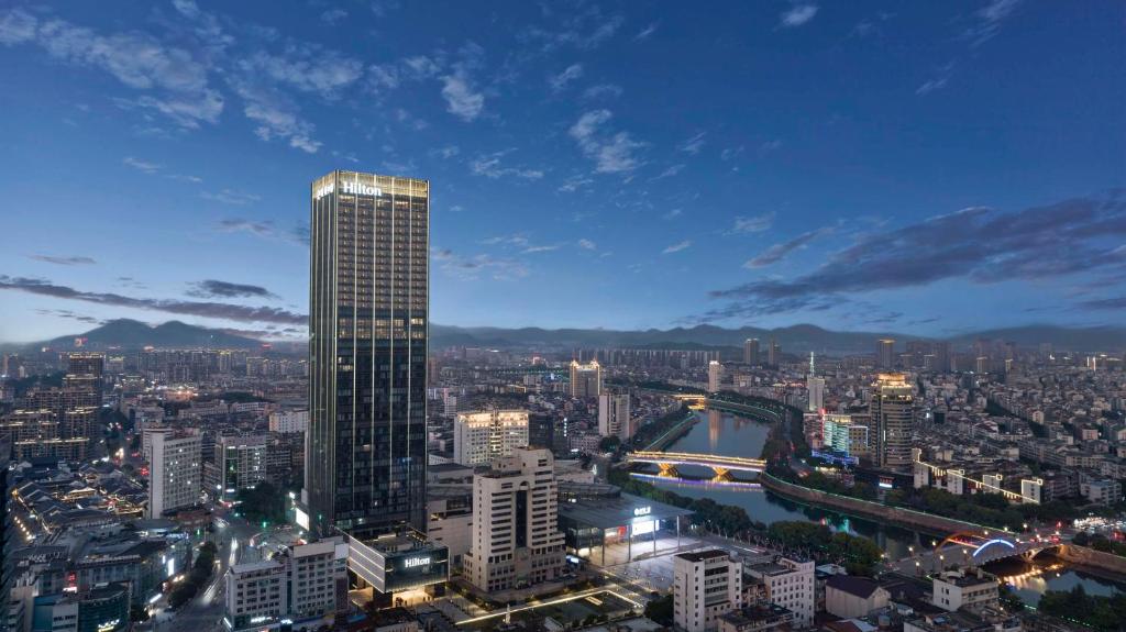 vista su una città con un grattacielo alto di Hilton Zhuji a Zhuji