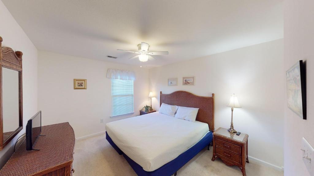 1 dormitorio con 1 cama y TV de pantalla plana en Pawleys Island Fairway Retreat 3BR Villa, en Pawleys Island