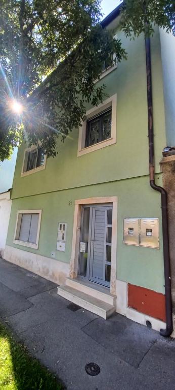 a green house with a blue door on a street at Vile Park Apartments Pula in Pula